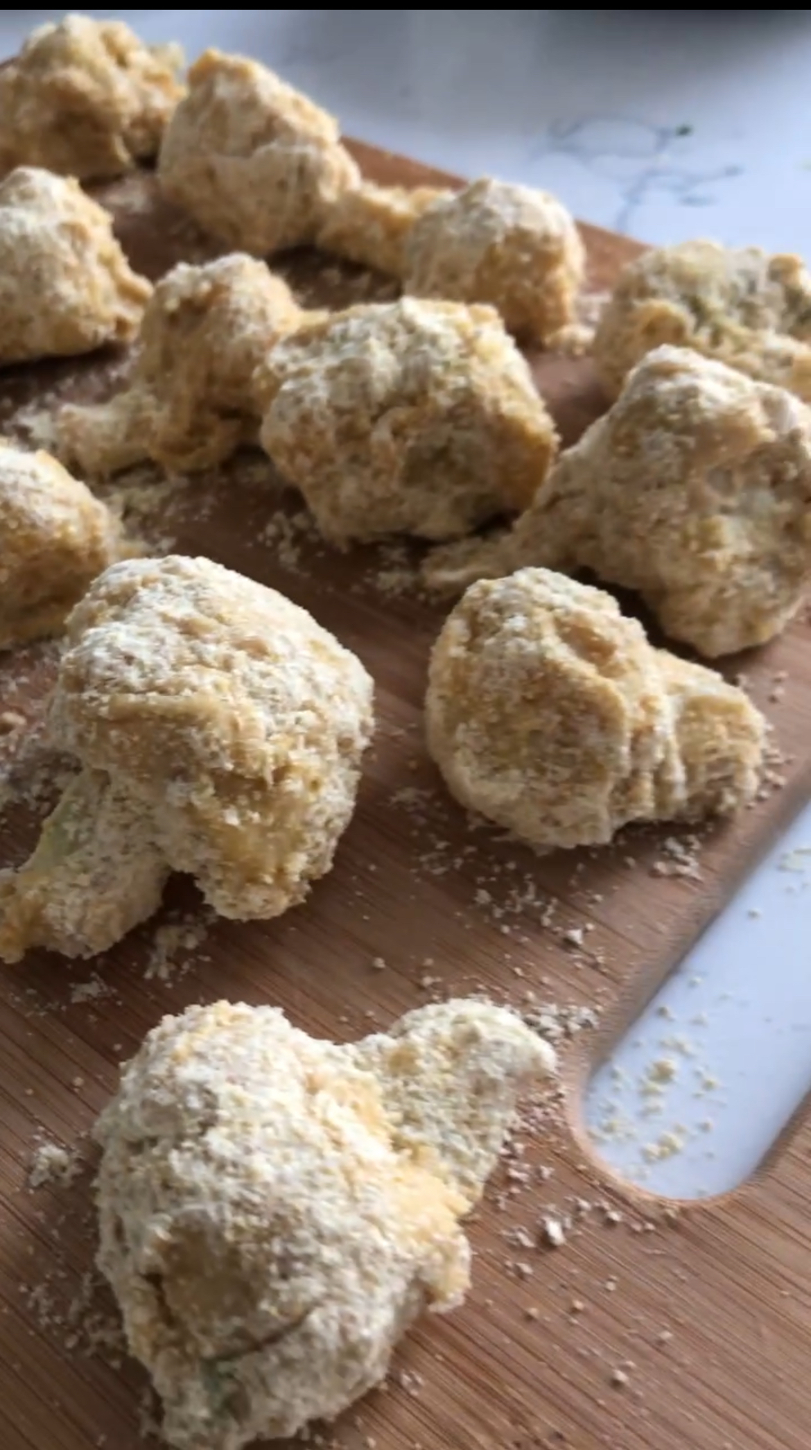 cauliflower florets dipped in batter, uncooked